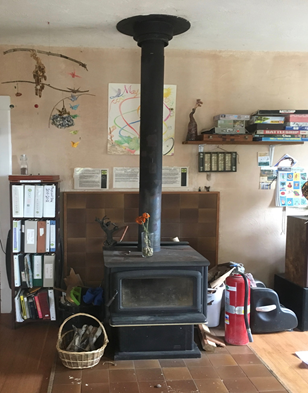 A woodstove in the CCAT common room served as the only source of space heating in the building as of 2019