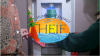 close up of two students trying out a new HEIF water bottle filling station with the HEIF logo in the foreground 